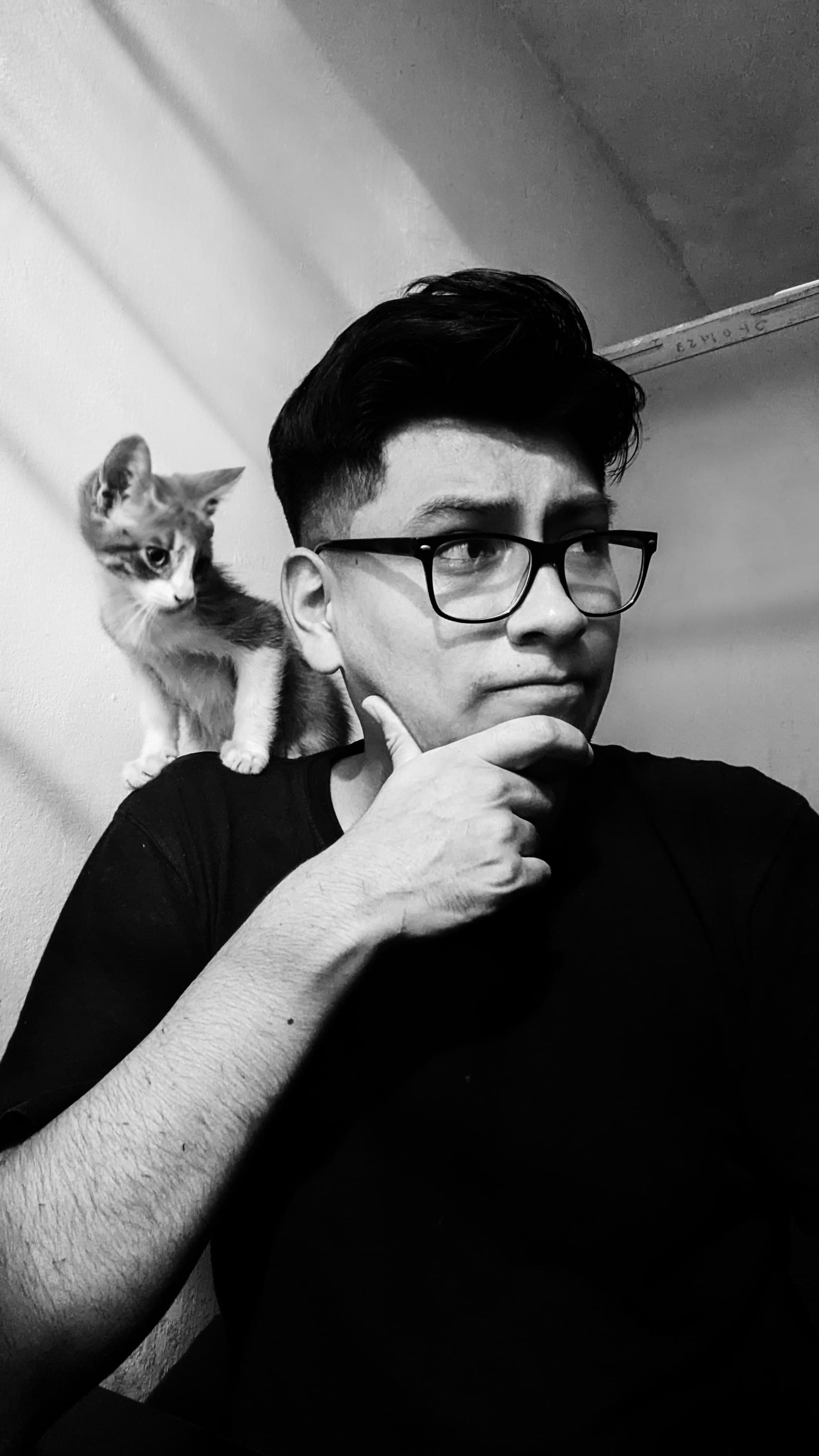 Retrato en blanco y negro de Aldair Dominguez con su gato